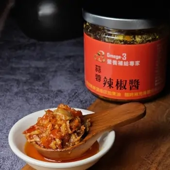 營養補給專家Omega-3 蒜香辣椒醬展示 一罐營養補給專家標有Omega-3的蒜香辣椒醬,前面擺放著一勺蒜香辣椒醬